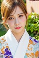 A woman in a colorful kimono poses for a picture.